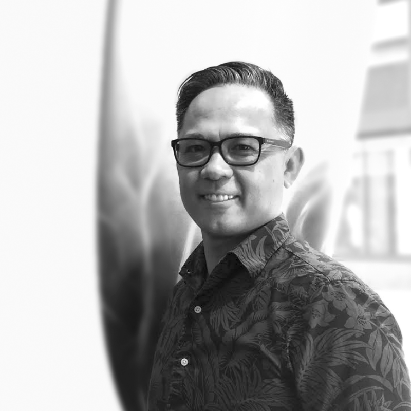 Luan Pham, Chief Revenue and Marketing Officer for Laird Superfood, is pictured in black and white. Luan is smiling, wearing glasses and a floral-printed shirt.